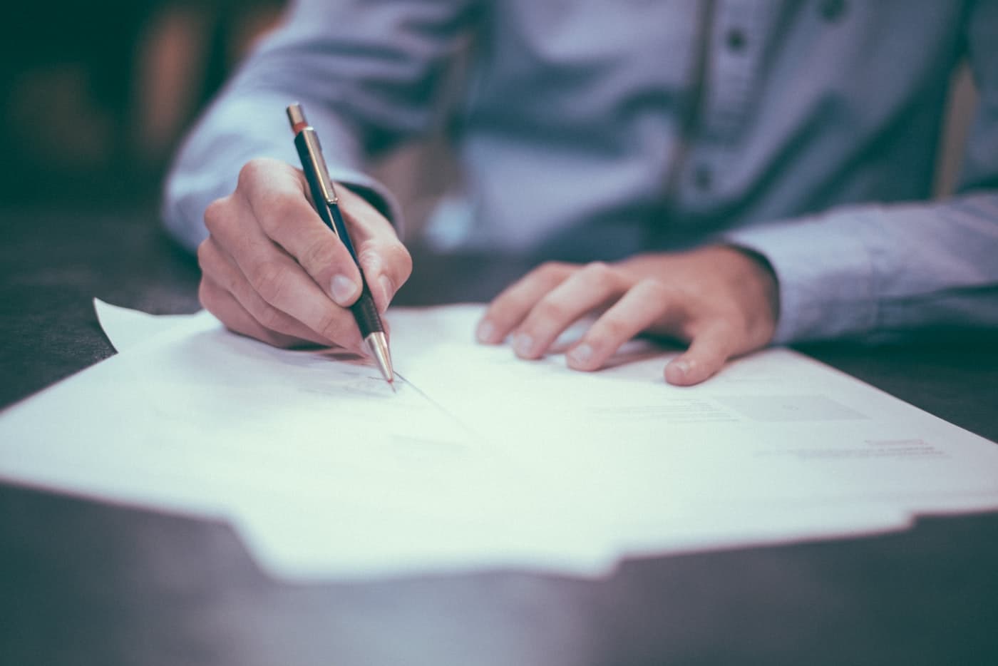 A lawyer signing a document at a desk.